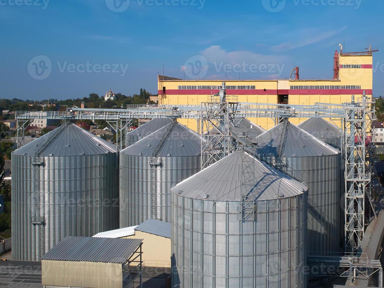 Agricultural Silo. Storage and drying of grains, wheat, corn, soy, against the blue sky with clouds. photo