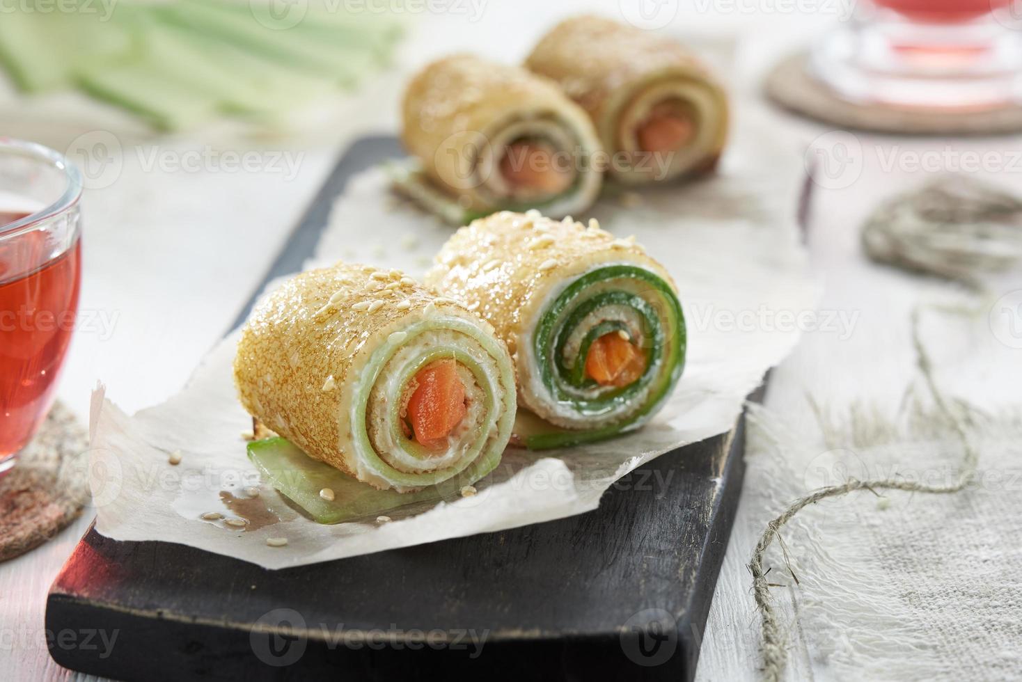 Homemade pancakes rolls with red fish, soft cheese and cucumber. photo