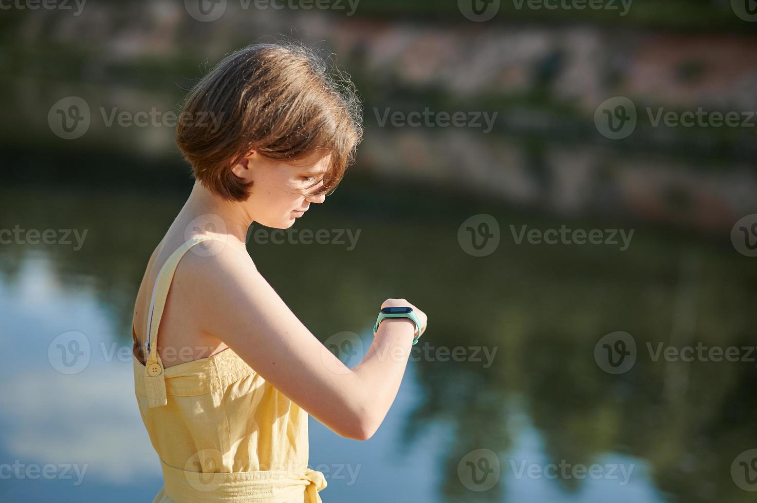 A teenage girl sets up a fitness tracker. Walking tour. photo