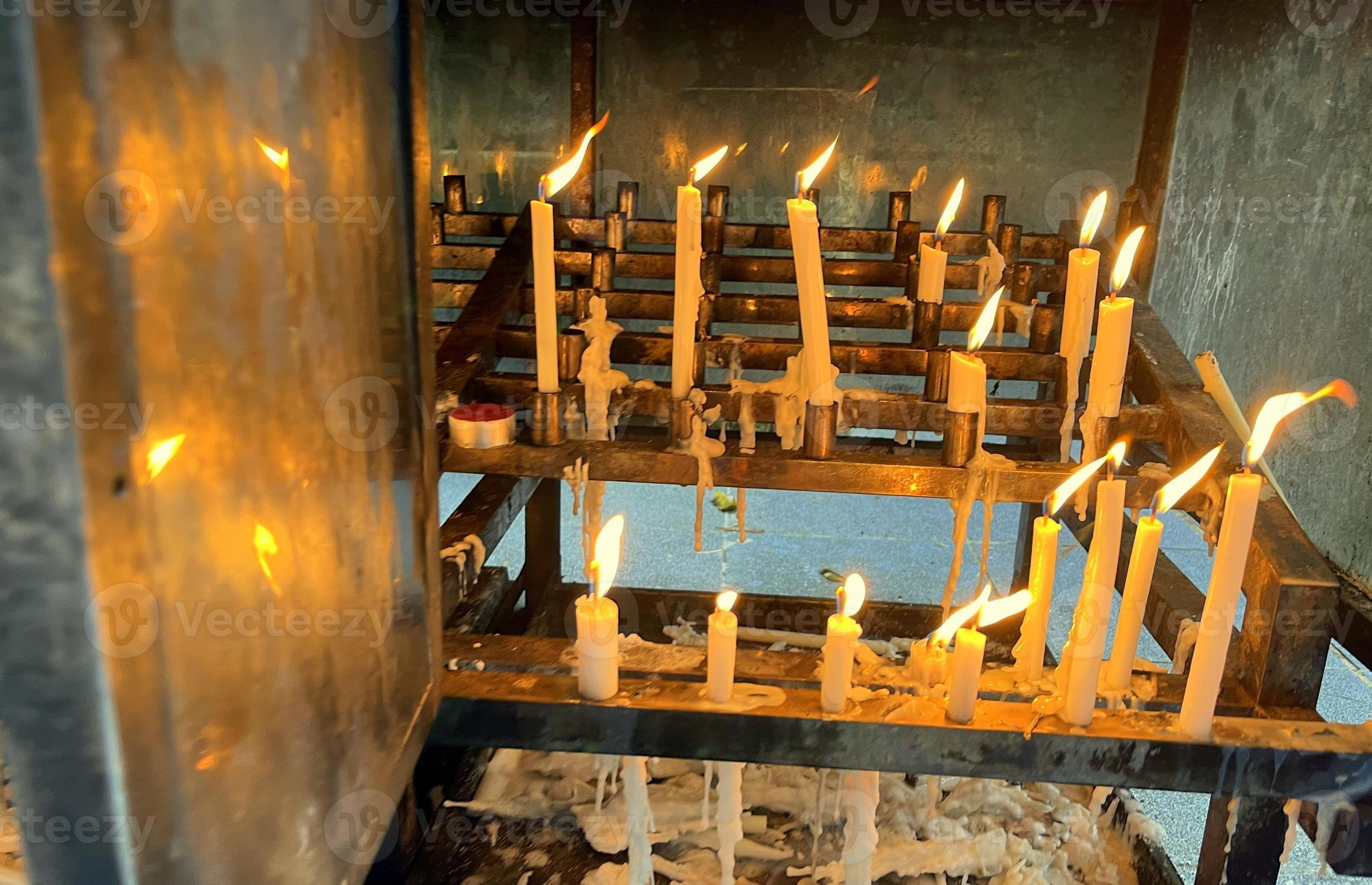 Bunch of prayers candle flames glowing in the dark create a spiritual