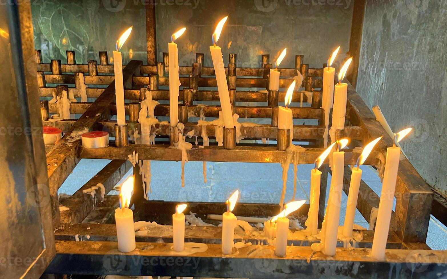 Bunch of prayers candle flames glowing in the dark create a spiritual