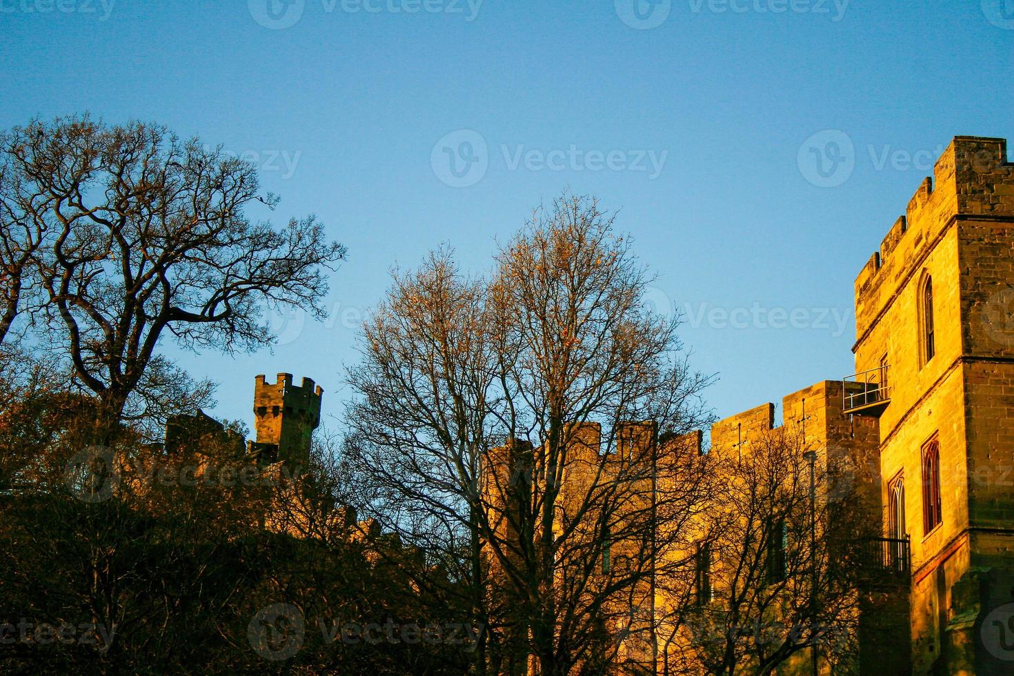 Ancient European medieval architectural building castle in golden autumn light with the blue sky background during autumn photo