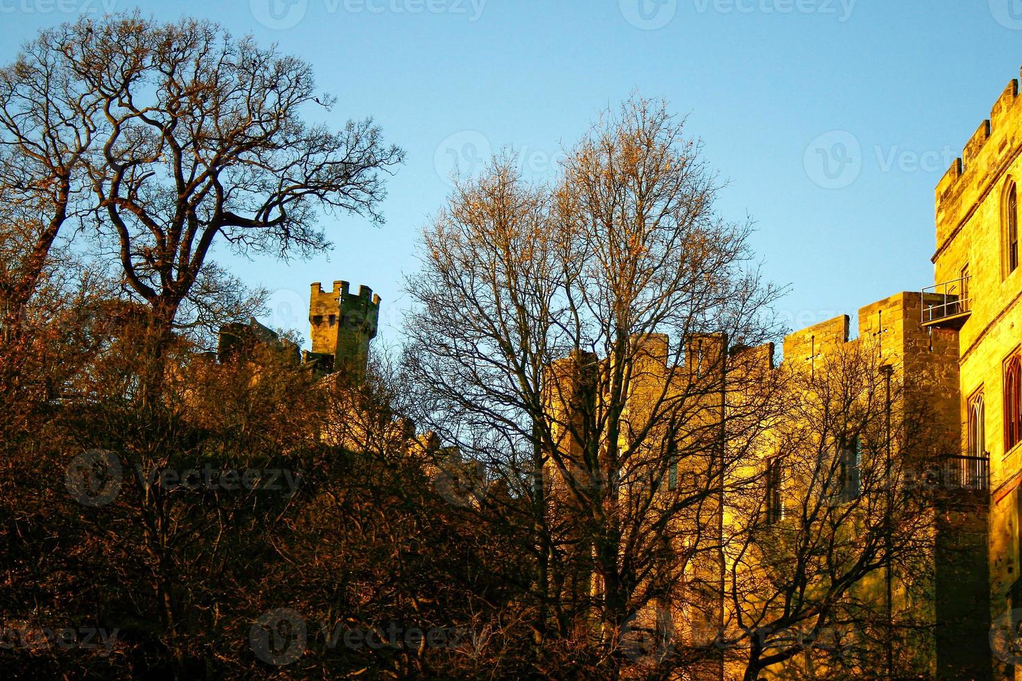 Ancient European medieval architectural building castle in golden autumn light with the blue sky background during autumn photo