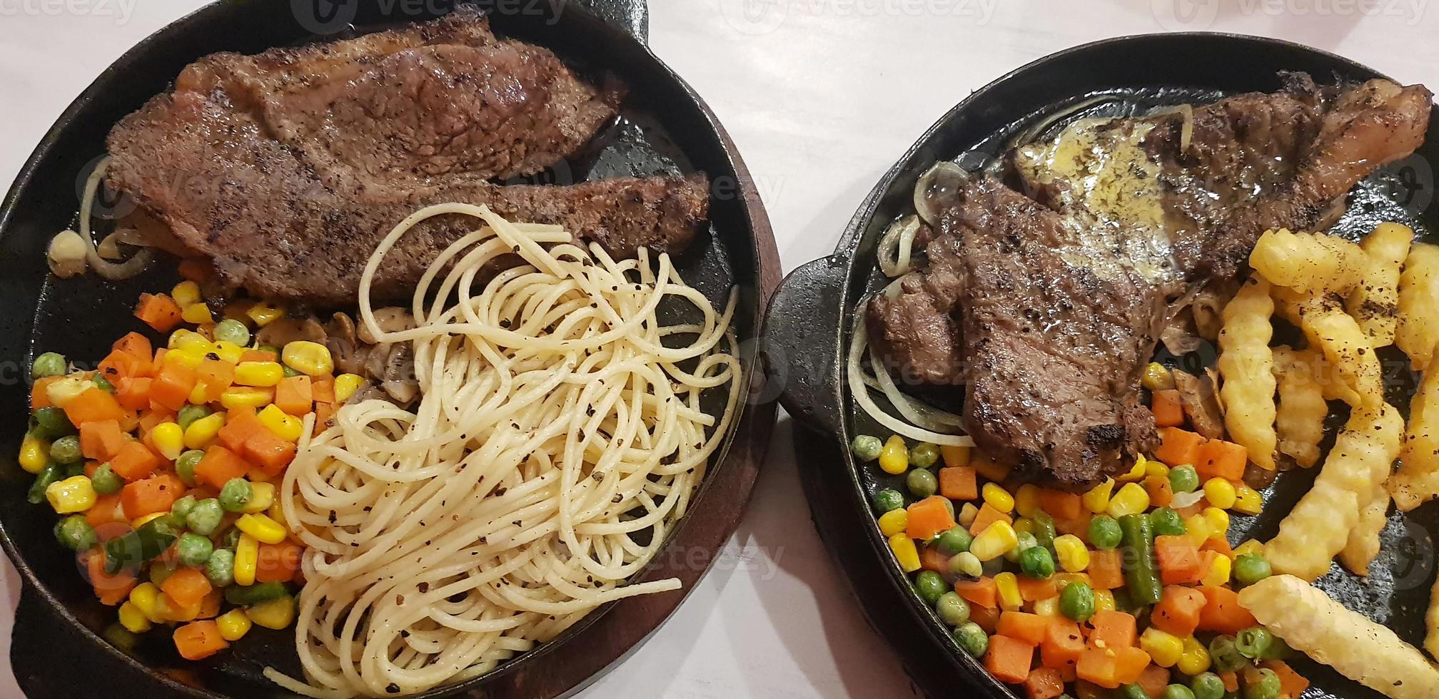 The best food in the world beef steak along with fried potatoes with delicious mushroom sauce and salad plated in beautiful black stripes plate photo