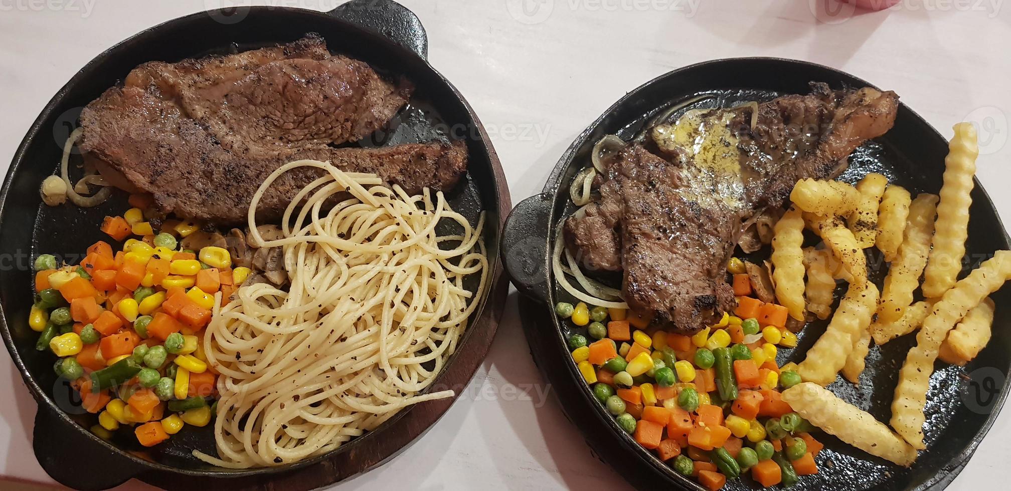 la mejor comida del mundo bistec de ternera junto con patatas fritas con deliciosa salsa de champiñones y ensalada en un hermoso plato de rayas negras foto