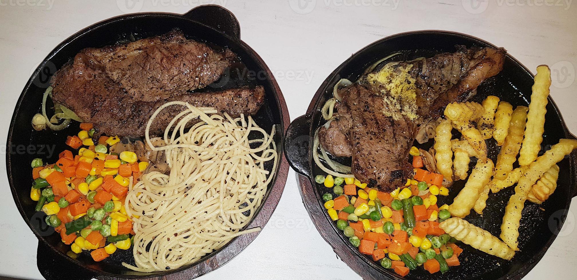 la mejor comida del mundo bistec de ternera junto con patatas fritas con deliciosa salsa de champiñones y ensalada en un hermoso plato de rayas negras foto