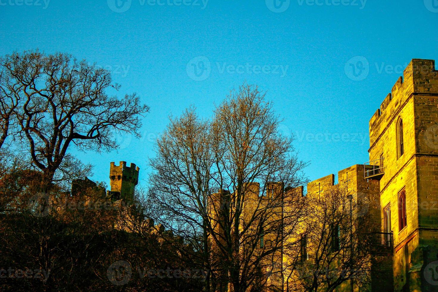 Ancient European medieval architectural building castle in golden autumn light with the blue sky background during autumn photo