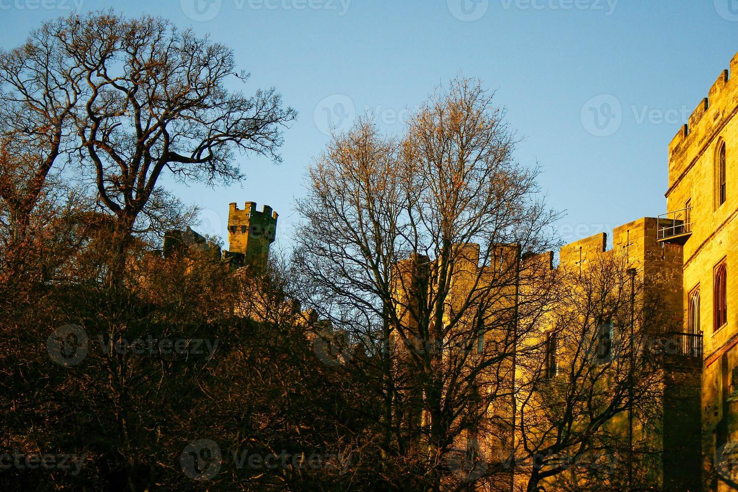 Ancient European medieval architectural building castle in golden autumn light with the blue sky background during autumn photo