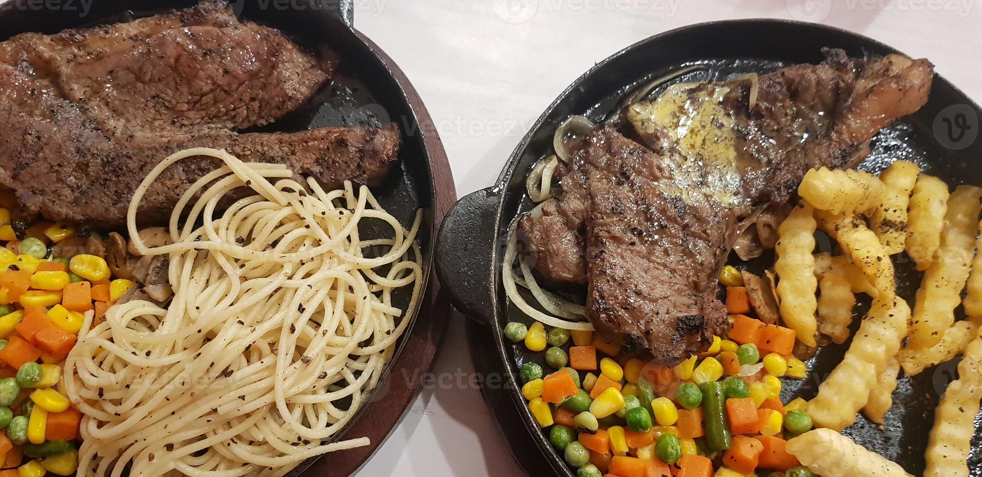 The best food in the world beef steak along with fried potatoes with delicious mushroom sauce and salad plated in beautiful black stripes plate photo