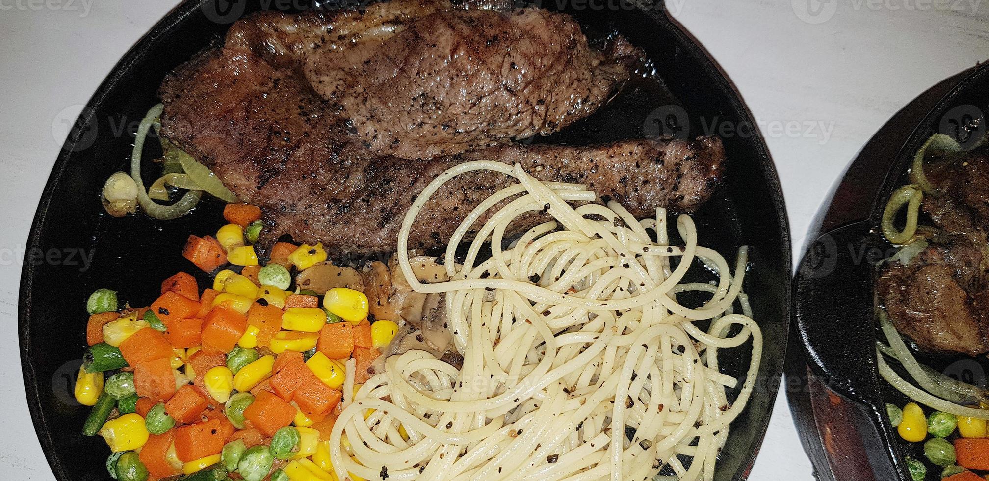 The best food in the world beef steak along with fried potatoes with delicious mushroom sauce and salad plated in beautiful black stripes plate photo