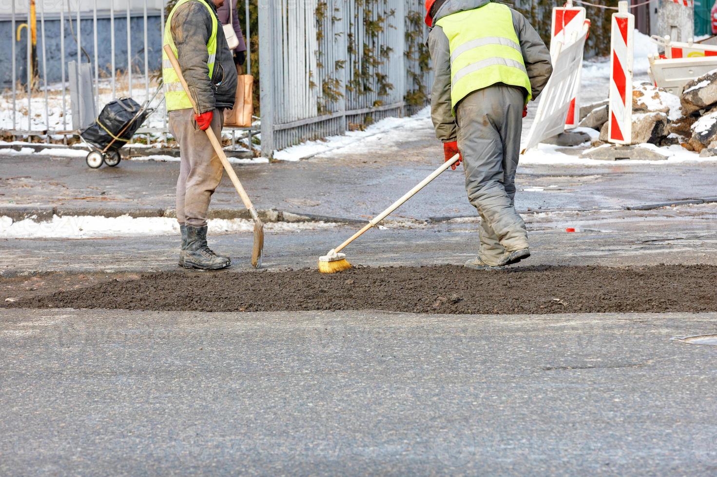 A construction team is patching up the pavement of the carriageway. photo