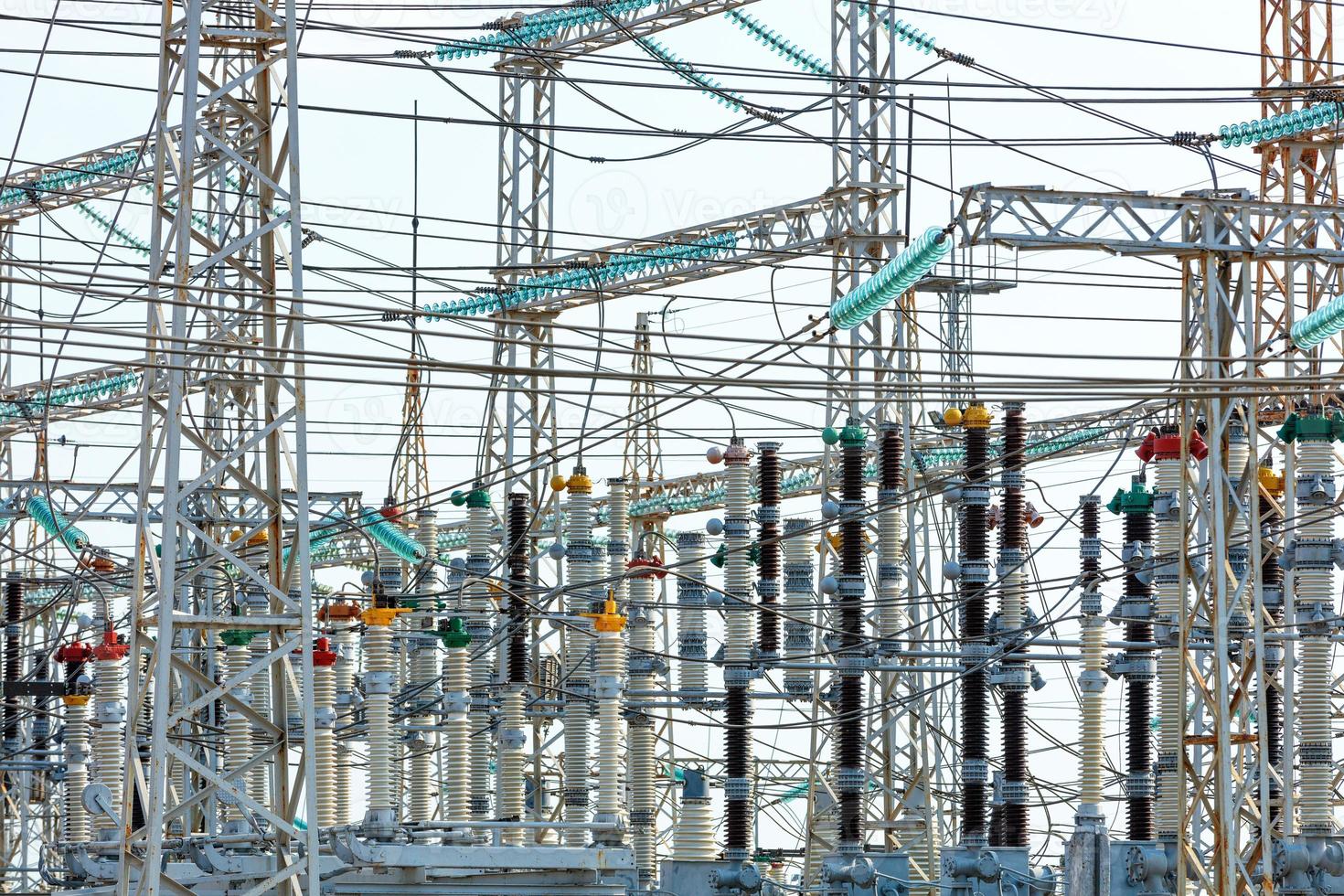 A web of electrical wires and high-voltage dielectric insulators on the metal masts of a substation during daylight hours. photo