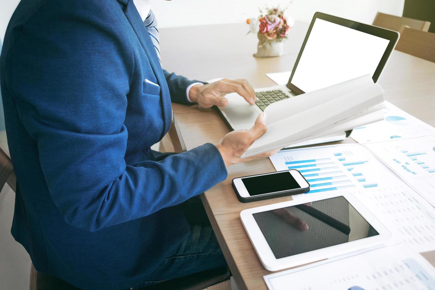 Young man working with laptop, tablet and smart phone, man's hands on notebook computer, business person at workplace. photo