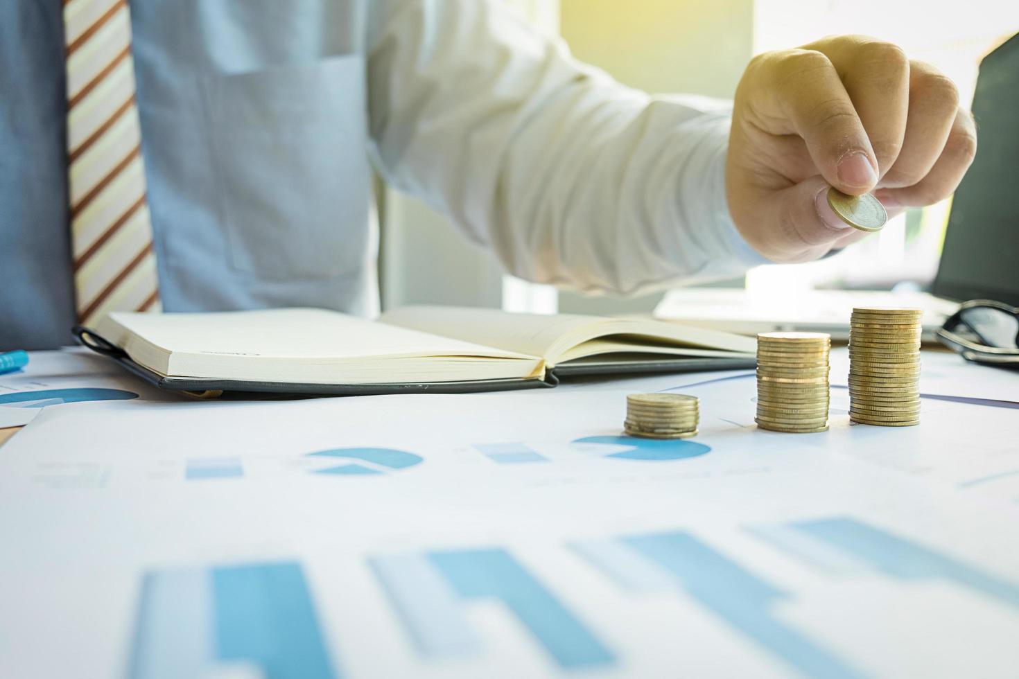 Close-up of Businessman putting coin to rising stack of coins. photo