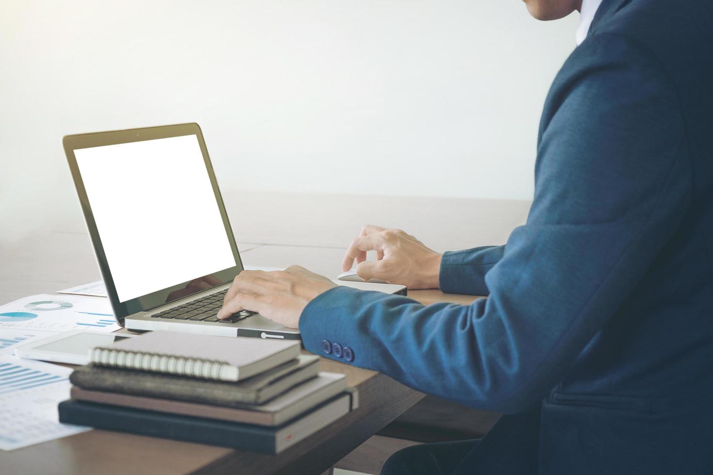 Image of business, Business man working at office with laptop and graph data documents on his desk. photo