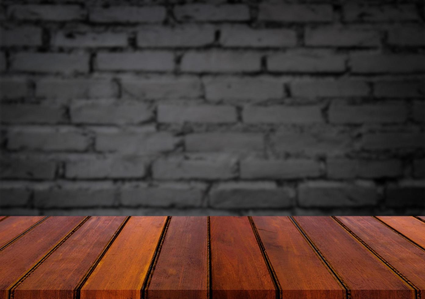 Selected focus empty brown wooden table and wall texture or old black brick wall blur background image. for your photomontage or product display photo