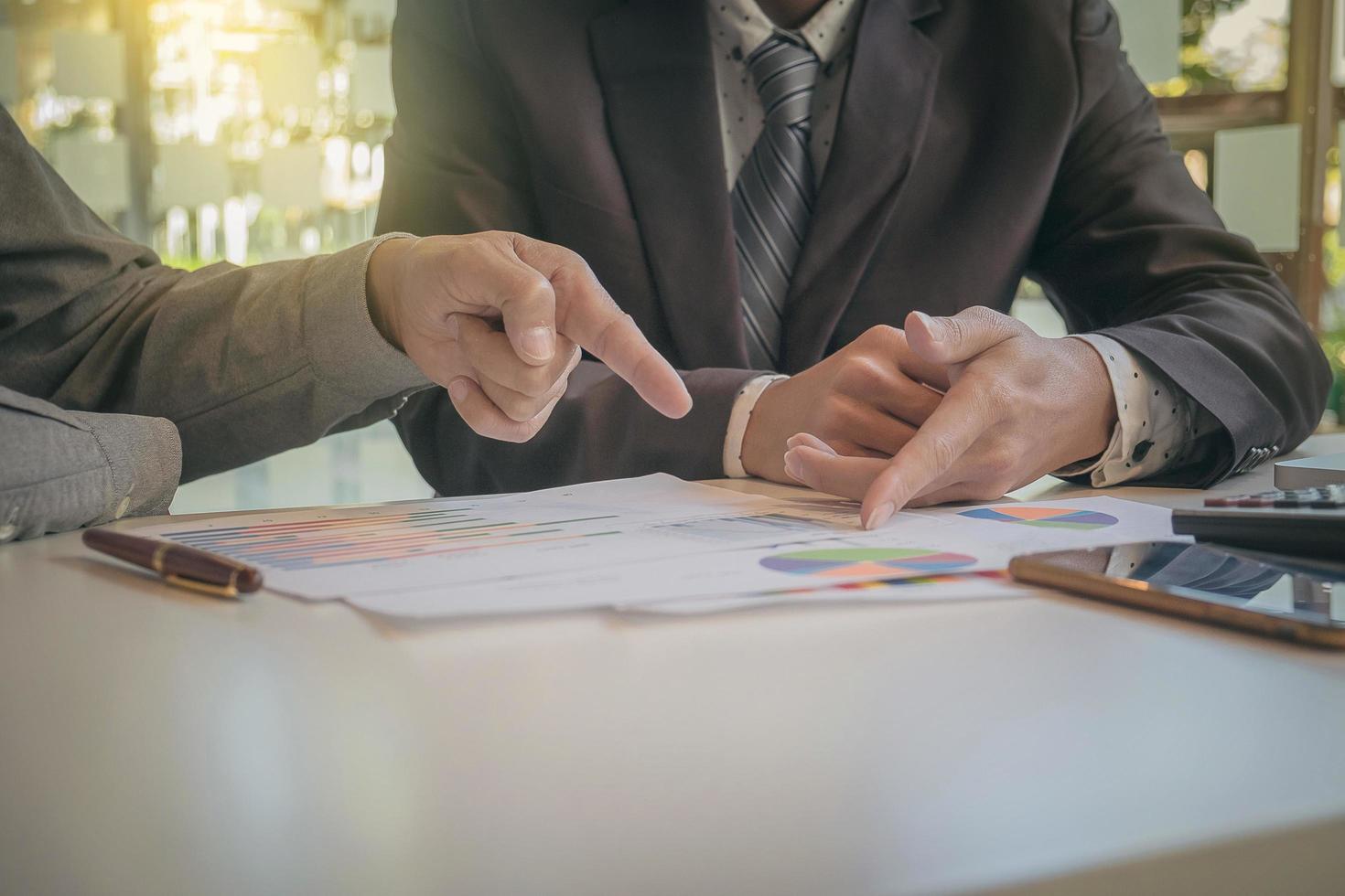 Two businessmen looking at report and having a discussion in office. business concept. photo