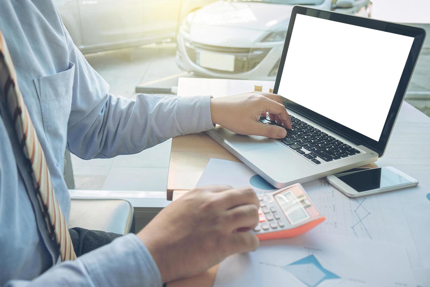 business man working with many document graph and laptop, calculator on his desk in morning light. business concept photo