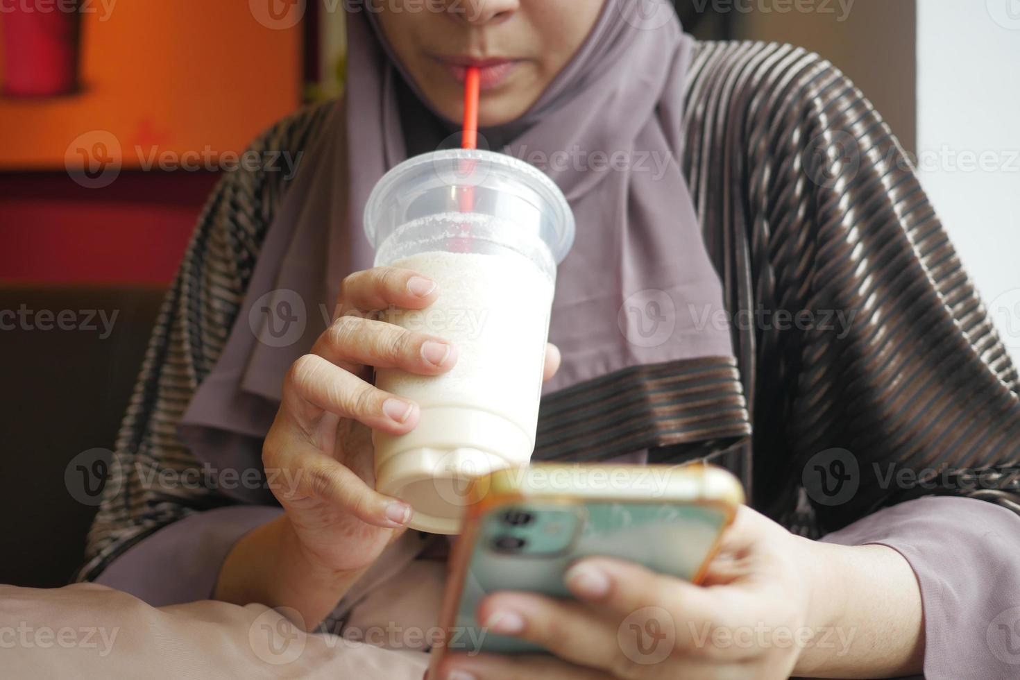 young women drinking banana milk shake at cafe photo