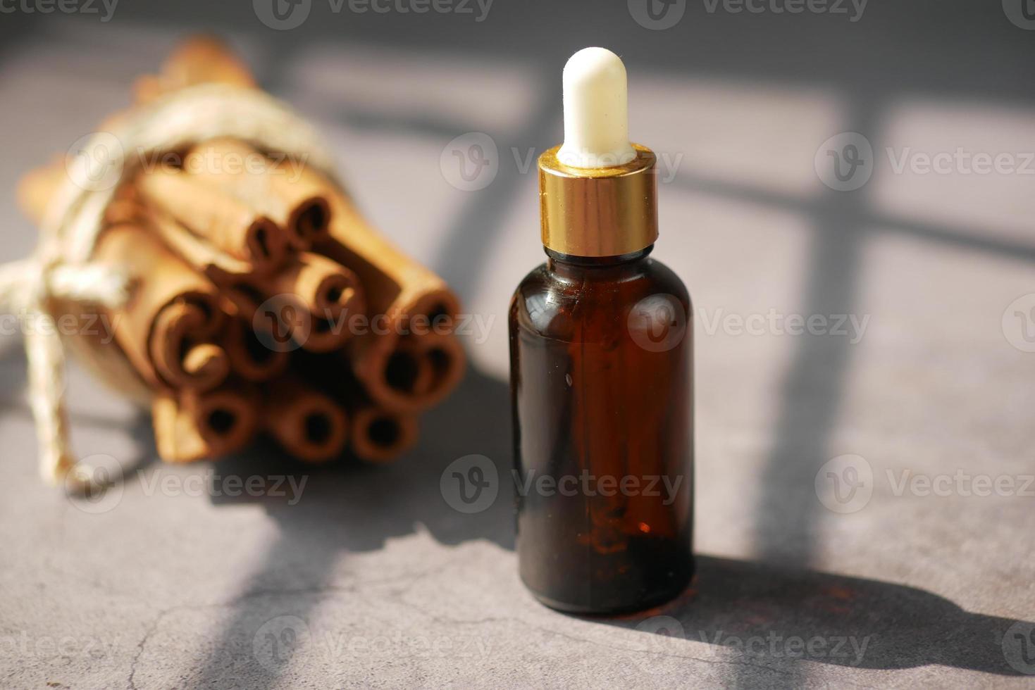 cinnamon essential oil in a container with sun light photo