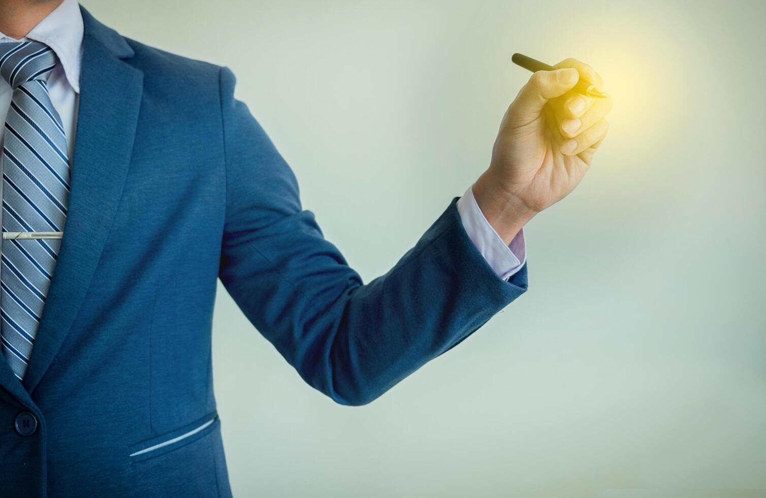 Businessman writing, drawing on the blank screen with copy space. photo