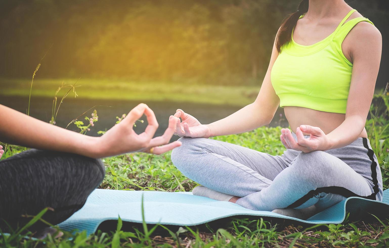 Young yoga practitioners in group doing yoga on nature, healthy lifestyle concept. photo