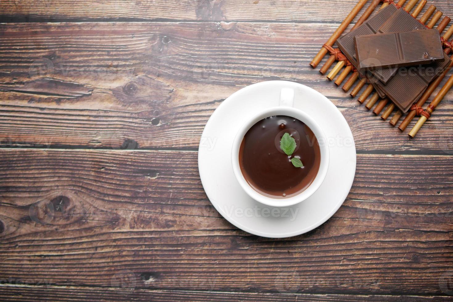 flat composition of dark chocolate cream in a coffee cup on table photo