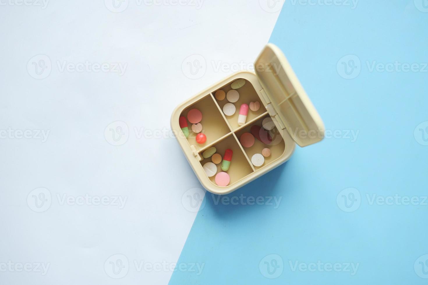 top view of medical pills in a pill box on table photo