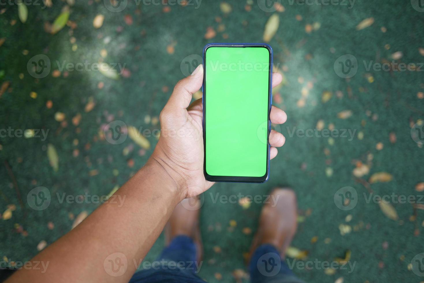 rear view of young man using smart phone at outdoor photo