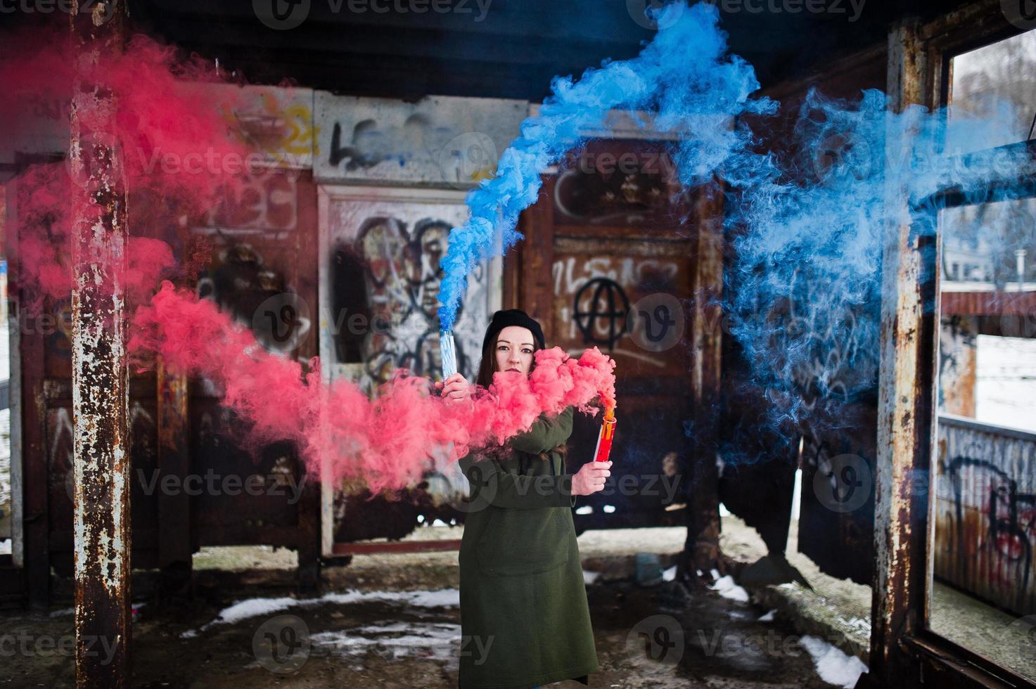 Young girl with blue and red colored smoke bomb in hands. photo