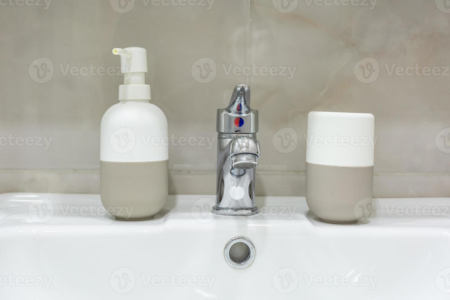 Soap and shampoo dispensers near Ceramic Water tap sink with faucet in expensive loft bathroom photo