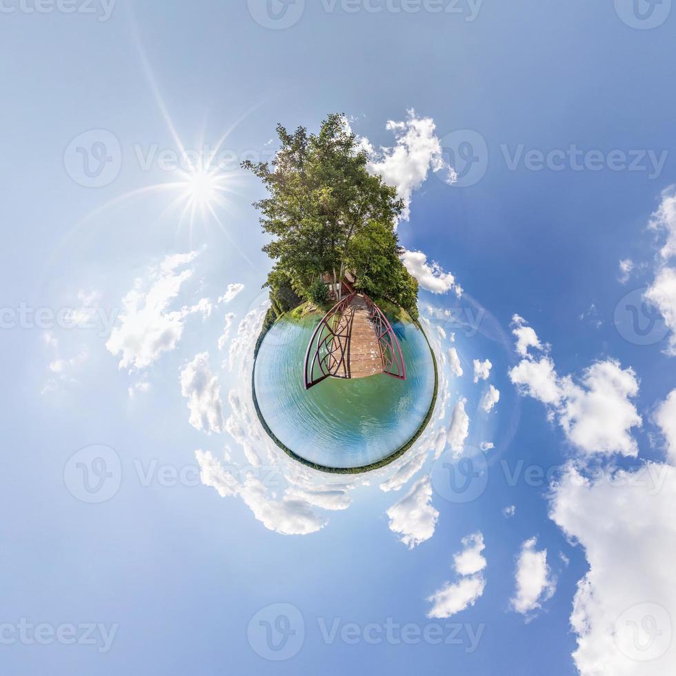 Little planet transformation of spherical panorama 360 degrees. Spherical abstract aerial view in field in nice evening with awesome beautiful clouds. Curvature of space. photo