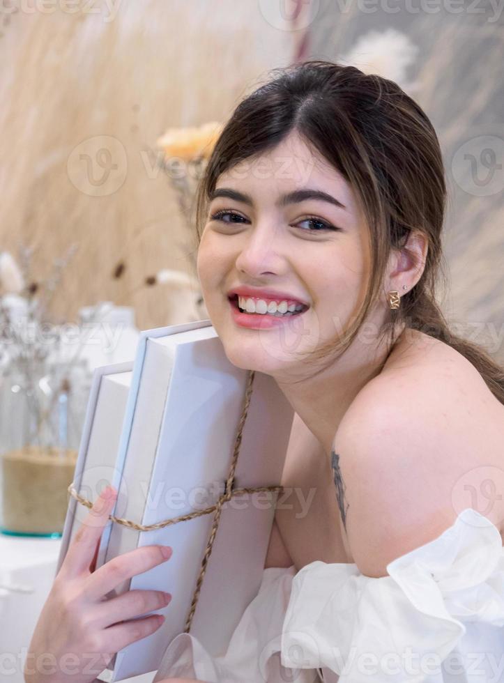 Portrait young  beautiful girl woman pretty smiling sitting attractive looking at book with a smile, happy and bright enjoy in dormitory university in home room . photo