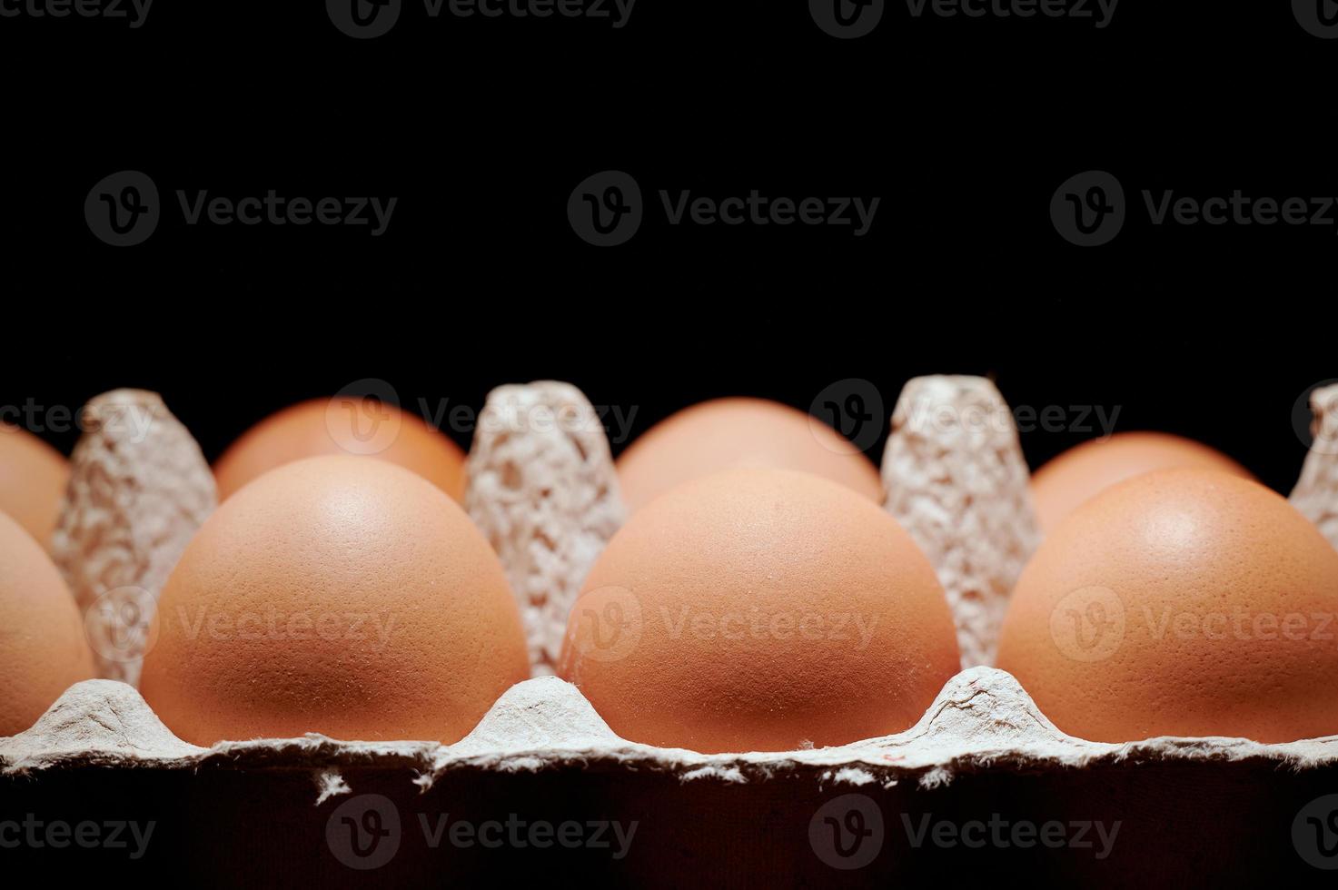Eggs in a protective container on black background. photo