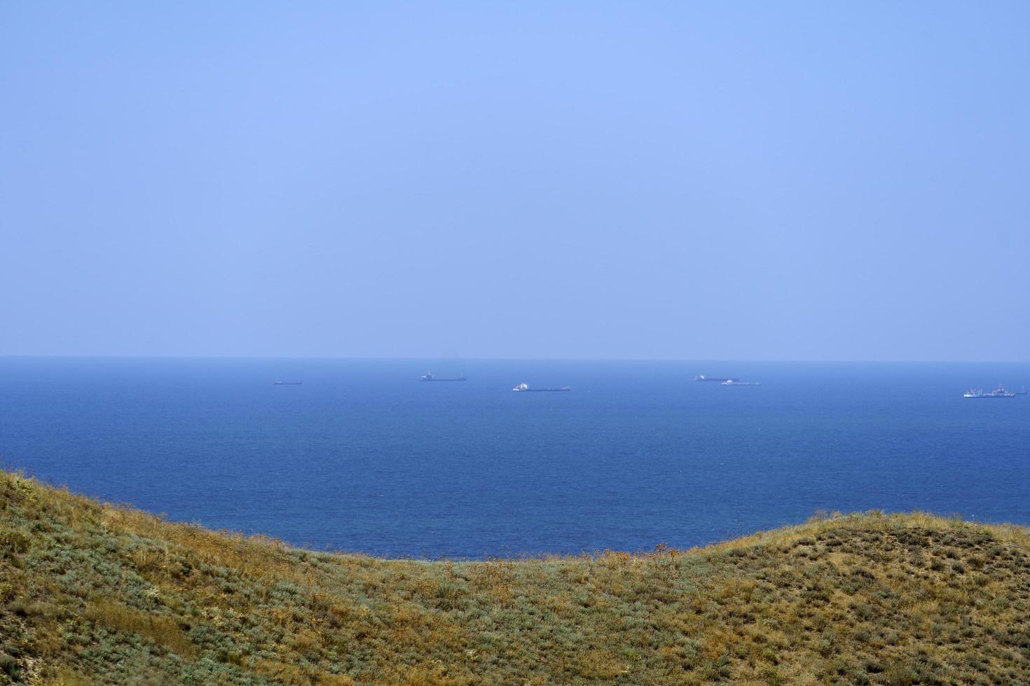 Seascape overlooking hills with dry grass photo