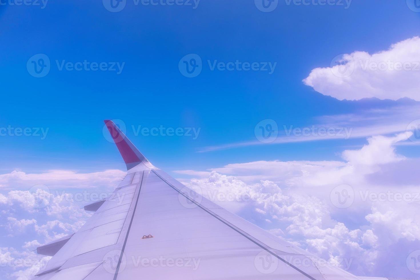 Wing of an airplane above white clouds. photo