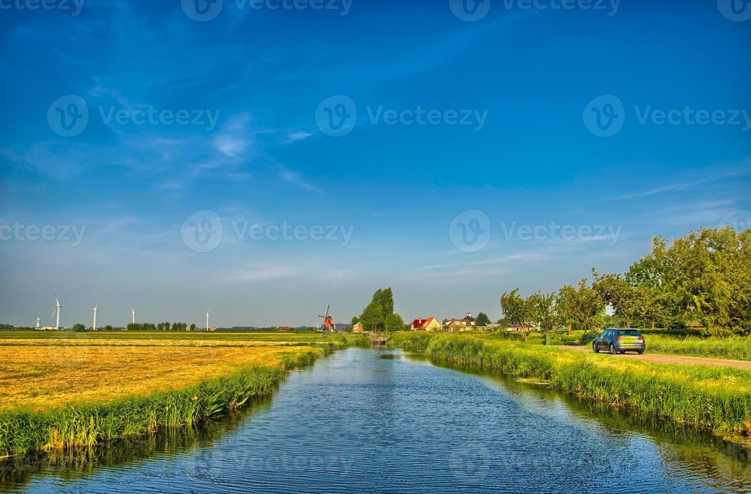 Dutch landscape with a canal and grass fields with mirror reflec photo