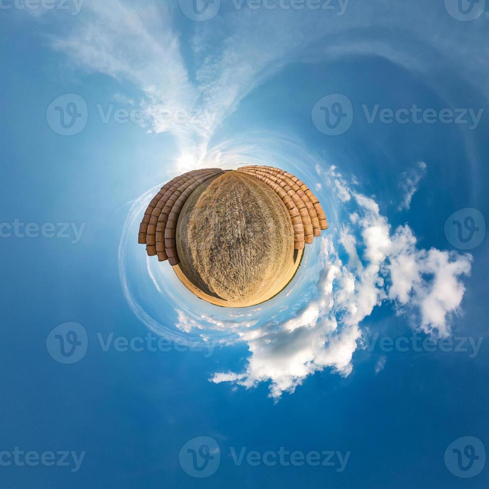 Little planet transformation of spherical panorama 360 degrees. Spherical abstract aerial view in field in nice evening with awesome beautiful clouds. Curvature of space. photo