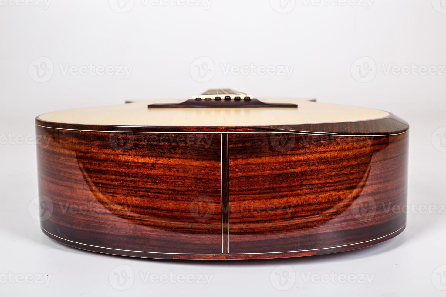 wood texture of lower deck of six strings acoustic guitar on white background. guitar shape photo