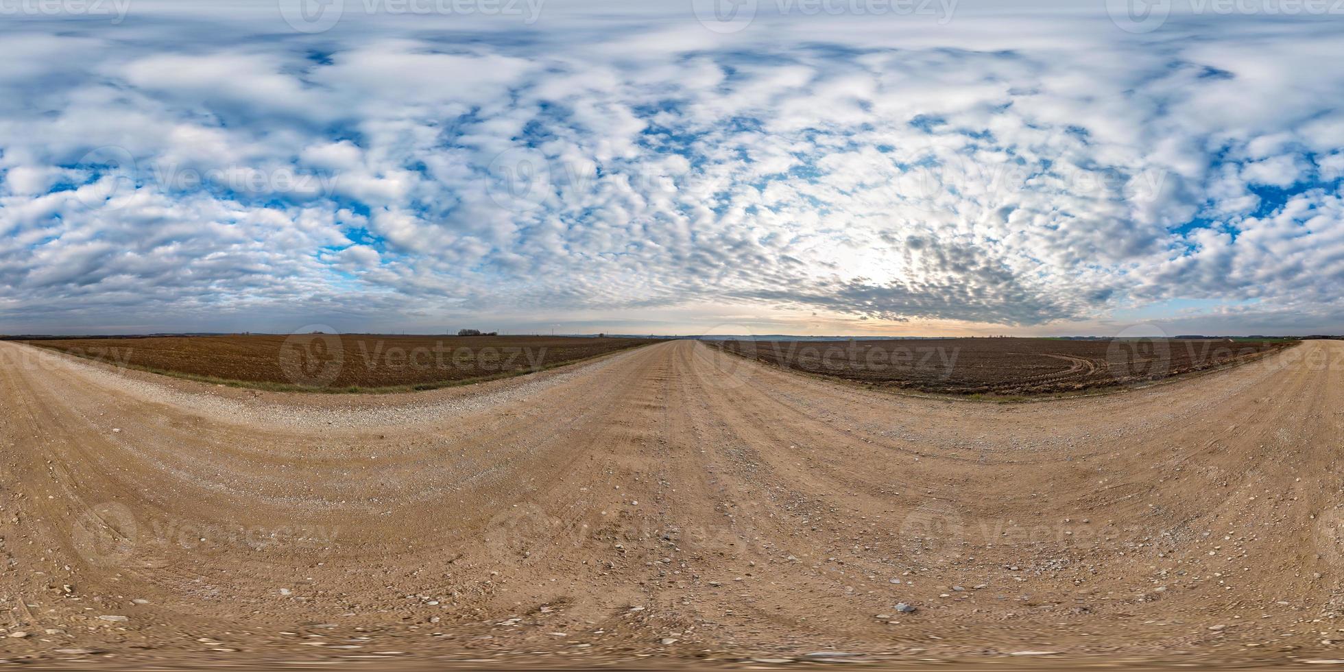 full seamless spherical hdri panorama 360 degrees angle view on gravel road among fields in autumn day with beautiful clouds in equirectangular projection, ready for VR AR virtual reality content photo