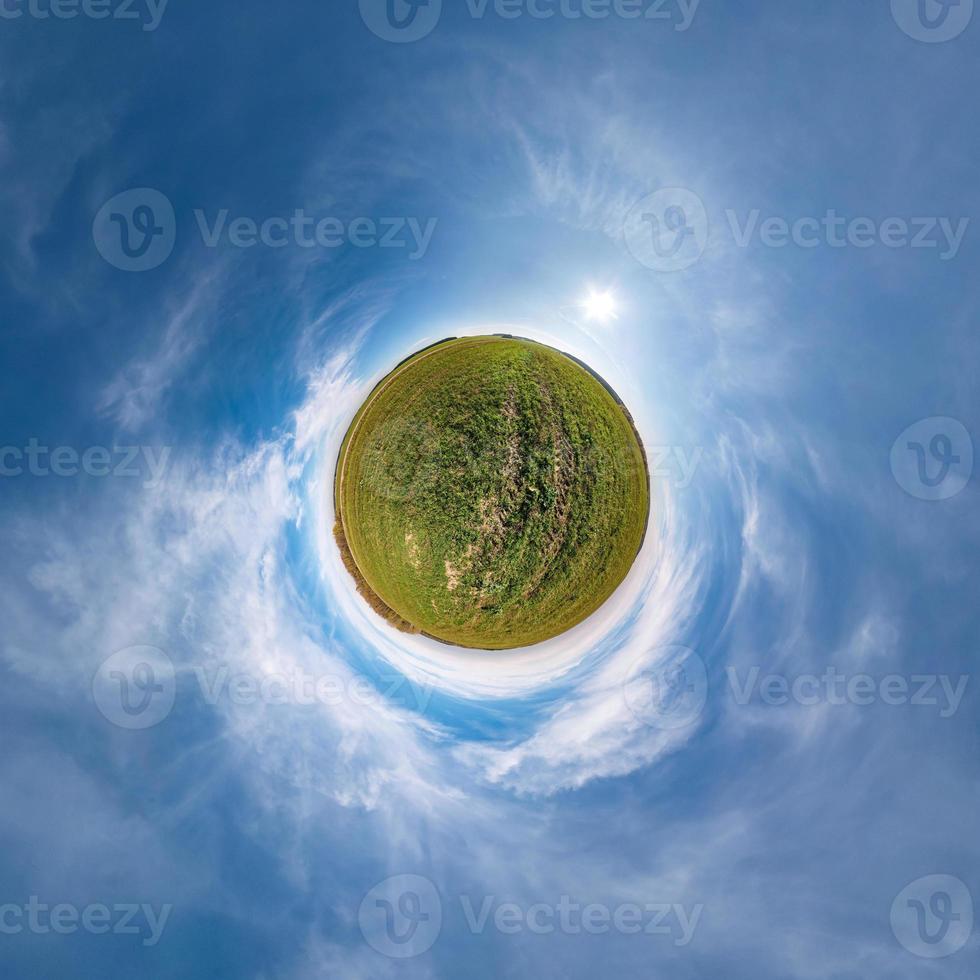 Little planet transformation of spherical panorama 360 degrees. Spherical abstract aerial view in field with awesome beautiful clouds. Curvature of space. photo