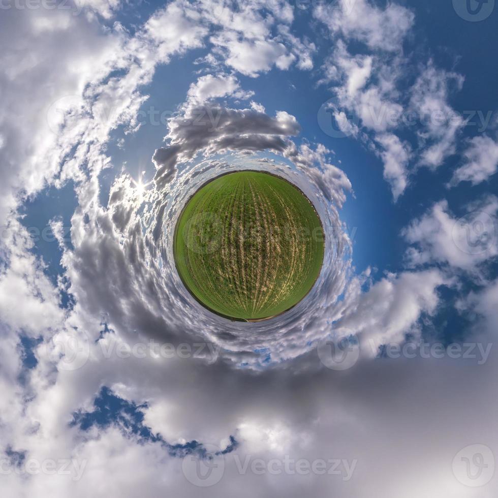 tiny planet in blue sky with sun and beautiful clouds. Transformation of spherical panorama 360 degrees. Spherical abstract aerial view. Curvature of space. photo