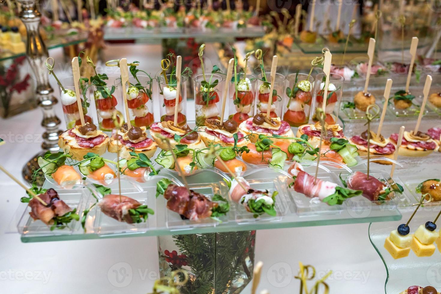 abastecimiento. comida fuera del sitio. mesa de buffet con varios canapés, sándwiches, hamburguesas y bocadillos. foto