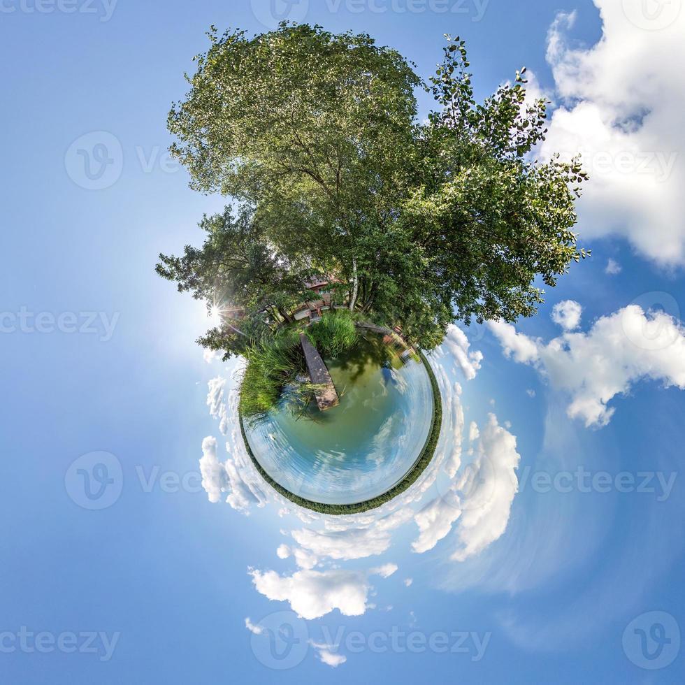 Little planet transformation of spherical panorama 360 degrees. Spherical abstract aerial view in field in nice evening with awesome beautiful clouds. Curvature of space. photo