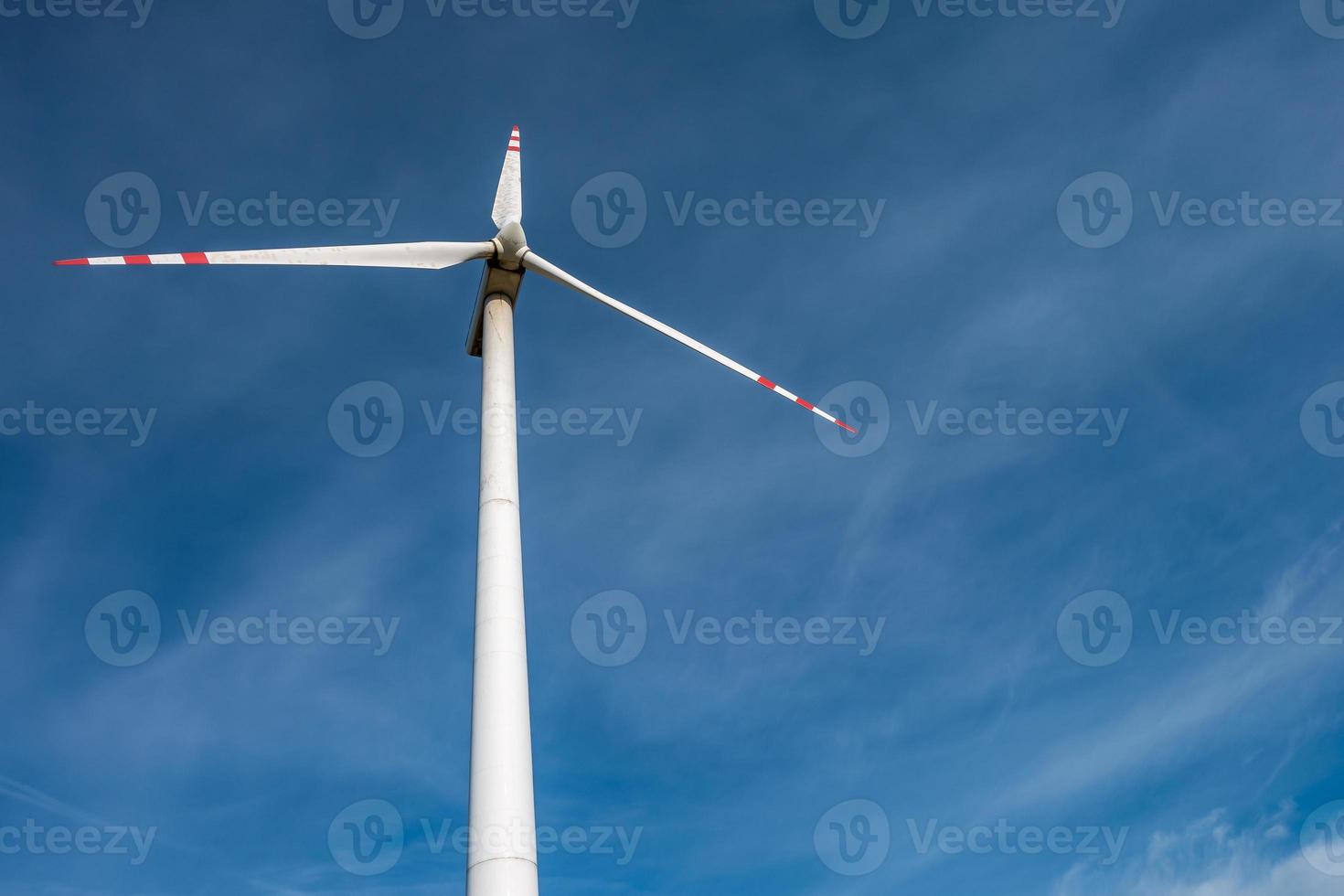 rotating blades of a windmill propeller on blue sky background. Wind power generation. Pure green energy. photo