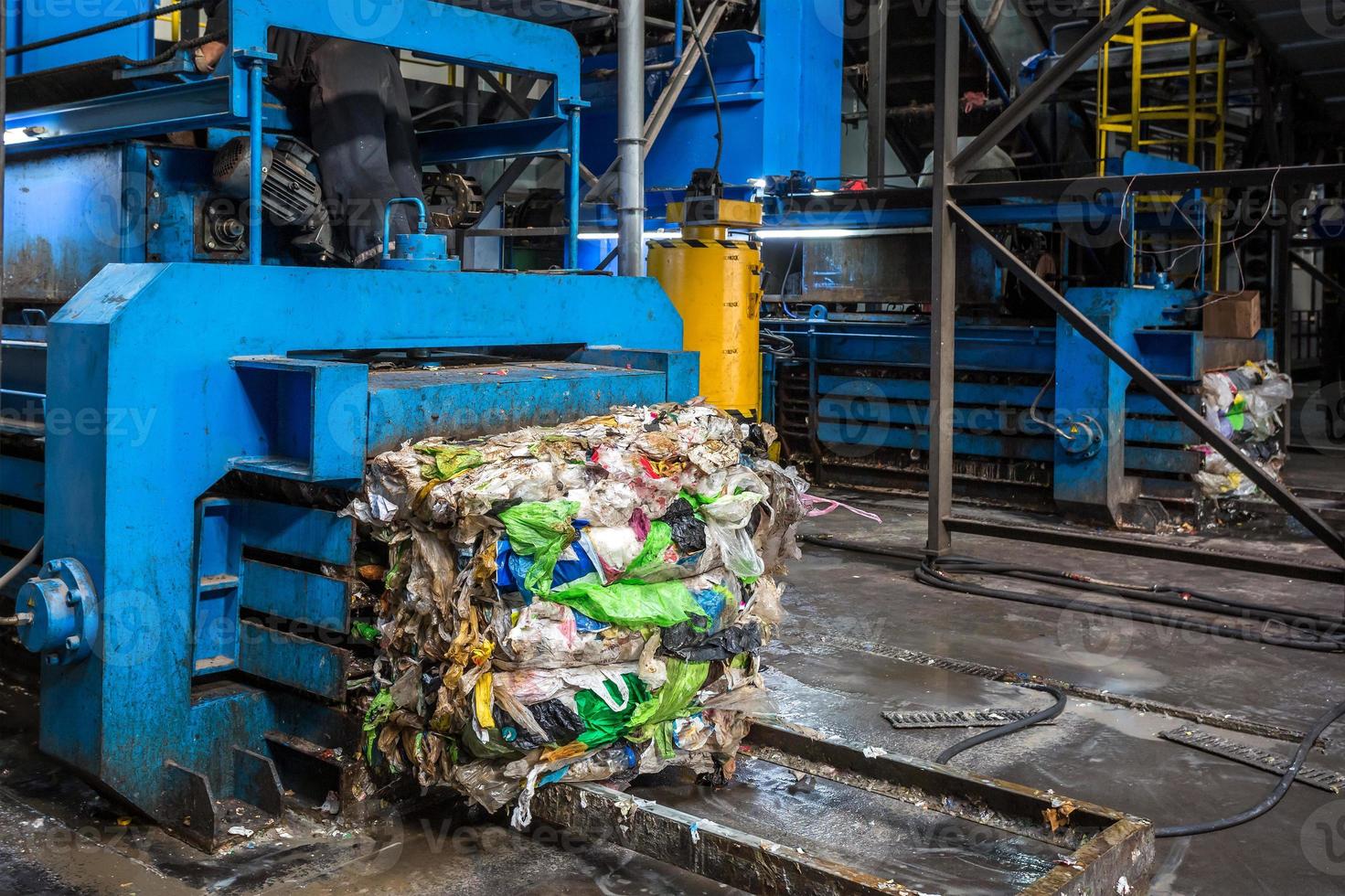 Equipment for pressing debris sorting material to be processed in modern waste recycling plant. garbage press on modern waste recycling processing plant. Business for sorting and processing of waste. photo