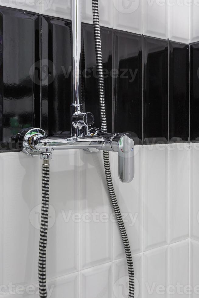 water tap sink with faucet in expensive loft bathroom. detail of a corner shower cabin with wall mount shower attachment photo