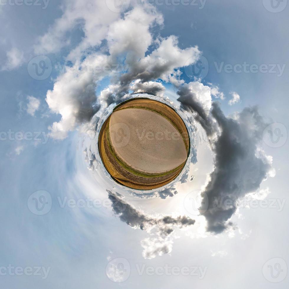 Little planet transformation of spherical panorama 360 degrees. Spherical abstract aerial view in field with awesome beautiful clouds. Curvature of space. photo