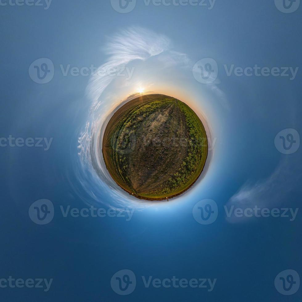 Little planet transformation of spherical panorama 360 degrees. Spherical abstract aerial view in field with awesome beautiful clouds. Curvature of space. photo