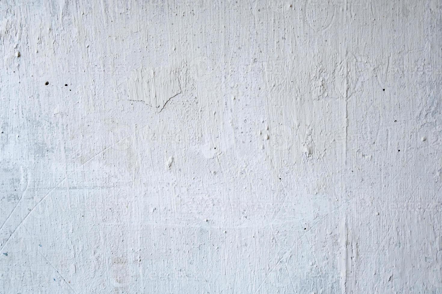 pintura blanca agrietada en la pared de hormigón foto
